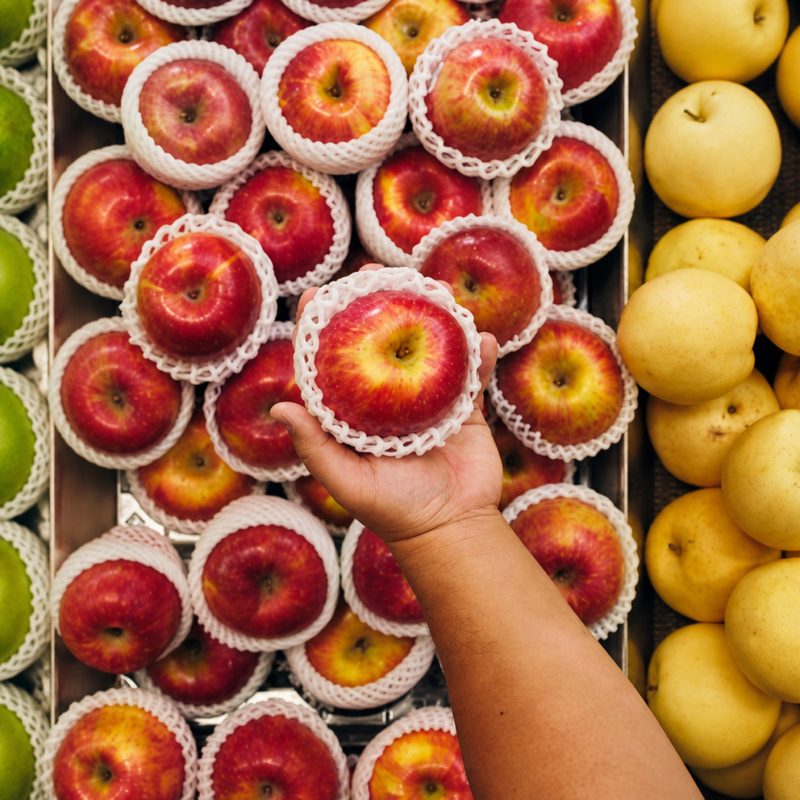 Hand selecting produce while shopping an order for a customer